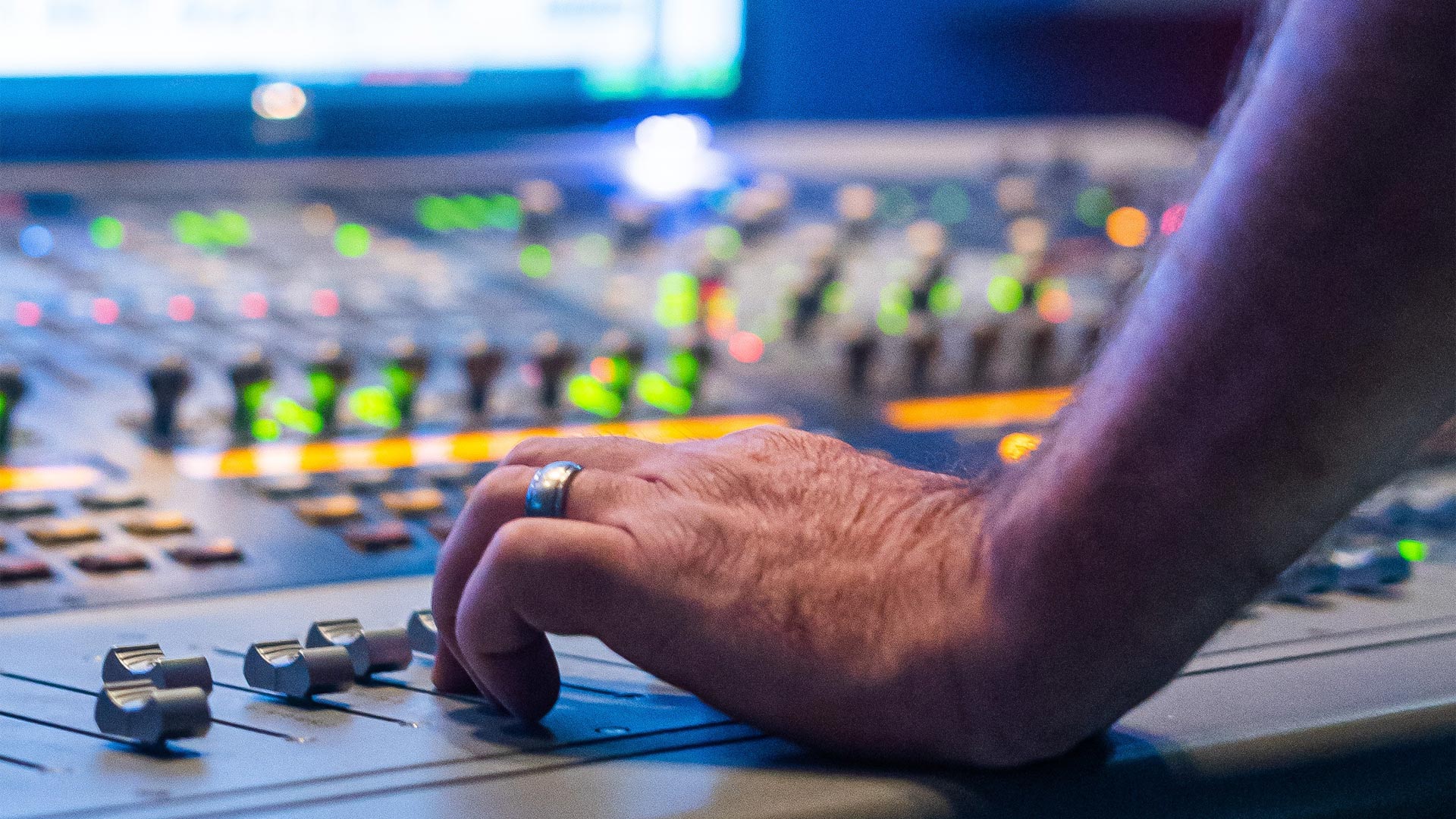 mano su uno dei fader di una console Avid (Digidesign)